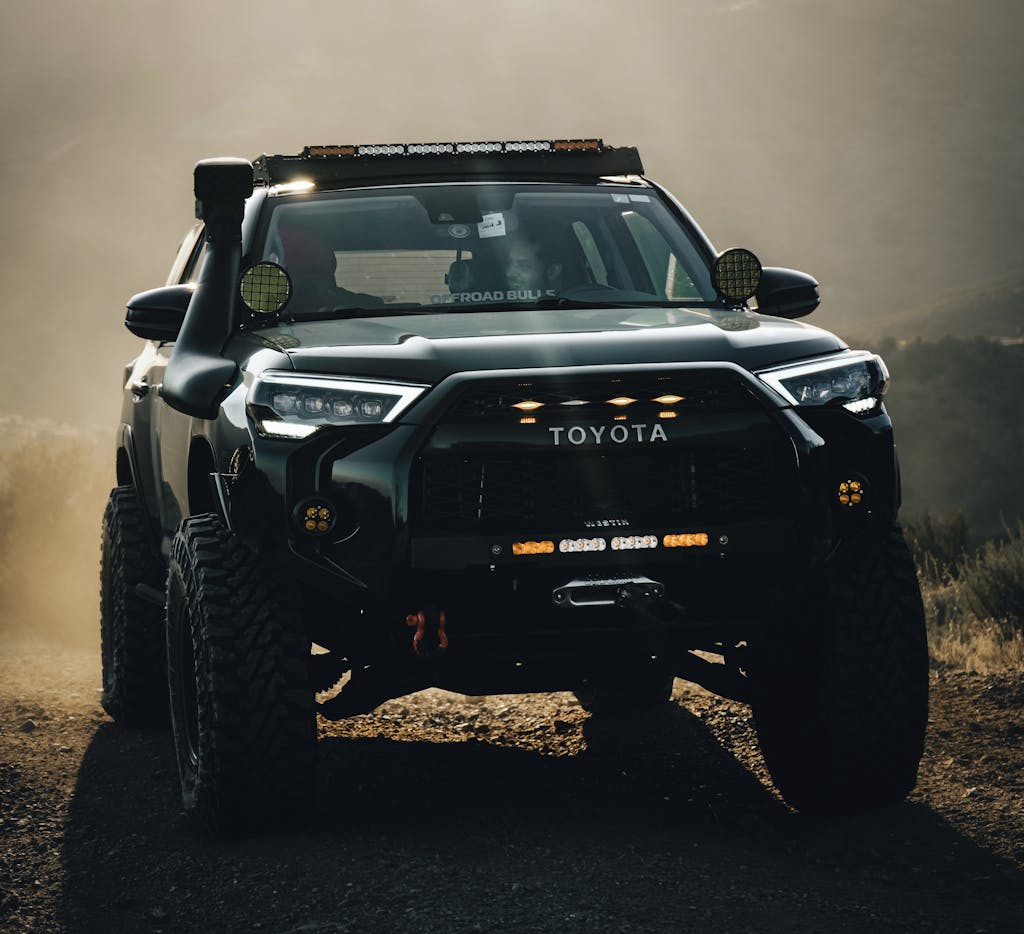 Powerful Toyota truck navigating rugged terrain in dusty conditions.